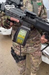 A Hamas soldier displaying an assault rifle labelled 'Negev'